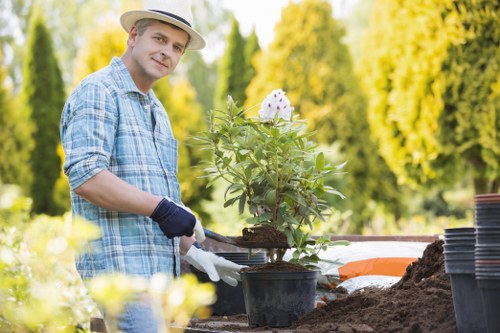 Worker wearing protective equipment operating garden machinery